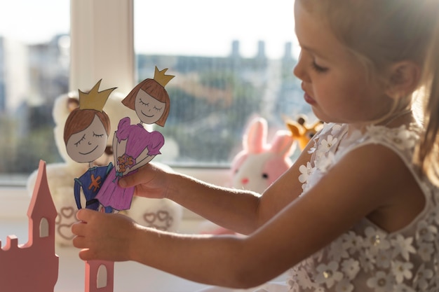 Маленькая девочка играет с куклами дома