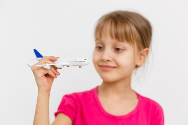 Маленькая девочка играет с игрушечным самолетиком