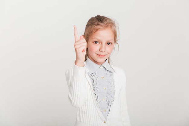 Little girl pointing up with finger