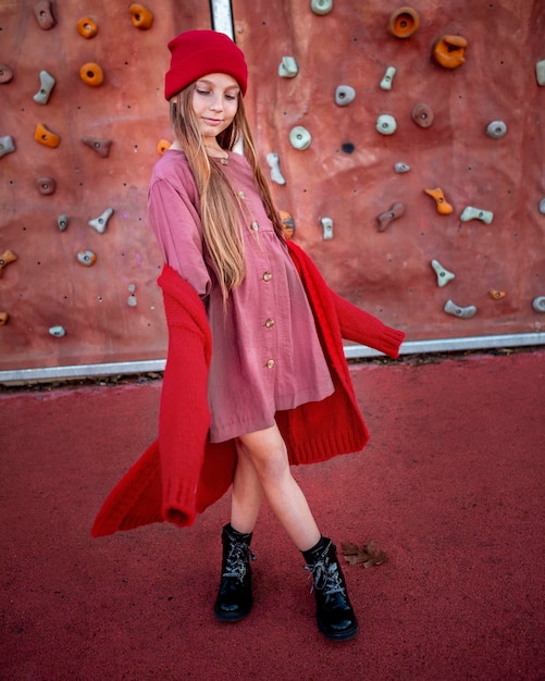 Little girl posing next to a climbing wall