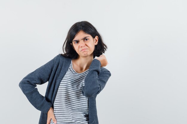 Tシャツ、ジャケットに立って物思いにふけるようにポーズをとっている少女。