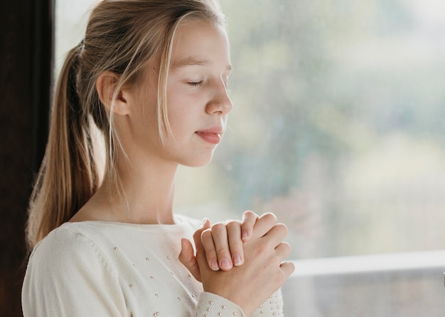 Little girl praying with copy space