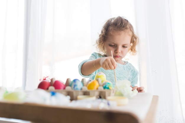 Little girl preparing eggs for Easter