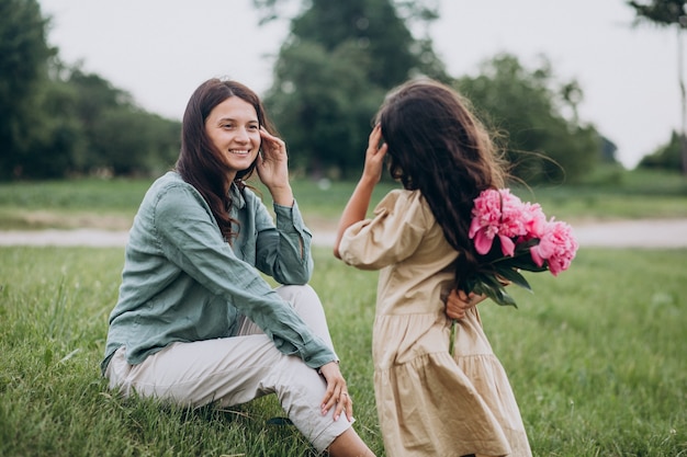 Free photo little girl presenting flowers to her mother