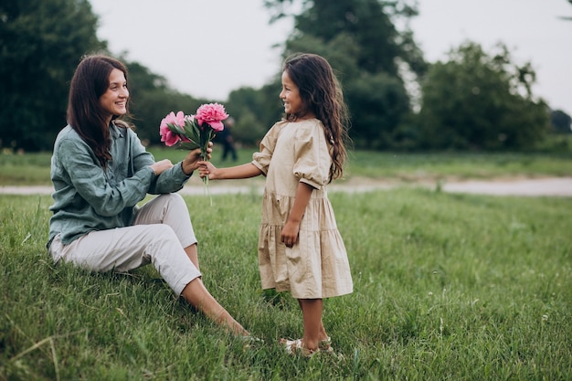 Бесплатное фото Маленькая девочка дарит цветы своей матери