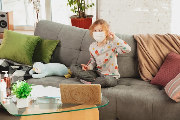 Little girl in protective mask isolated at home with coronavirus