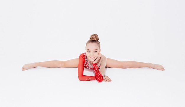 Foto gratuita bambina in vestito rosso che fa spaccatura ginnastica. isolato su sfondo bianco.