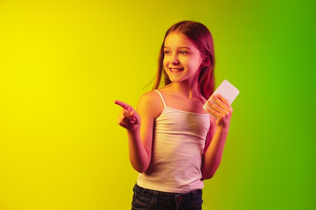 Little girl's portrait isolated on neon wall