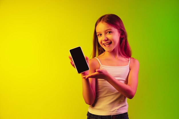 Little girl's portrait isolated on neon wall