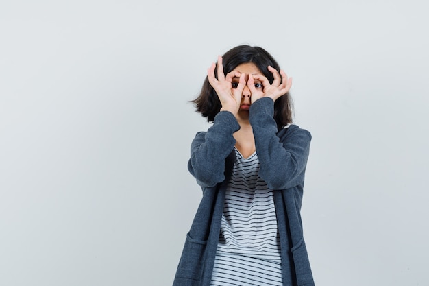 Little girl showing glasses gesture in t-shirt