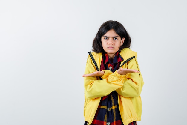 체크 셔츠, 재킷 및 주저 찾고 크기 기호를 보여주는 어린 소녀