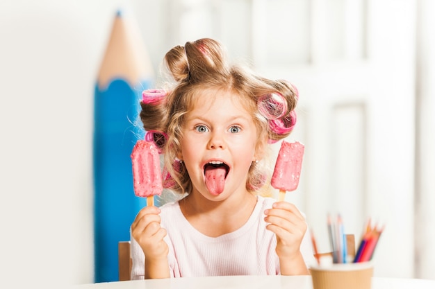 앉아서 아이스크림을 먹는 어린 소녀