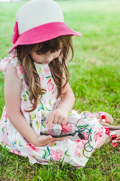 Little girl sitting on the floor with a phone in her hand