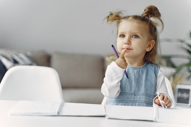 Little girl sitting on a table with books