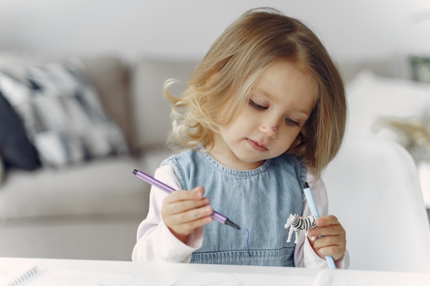 Little girl sitting on a table with books