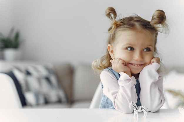 Little girl sitting on a table with toy