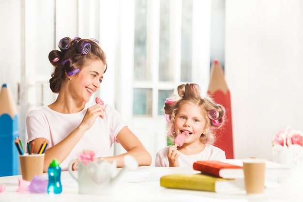 Little girl sitting with her mother and eating ice cream