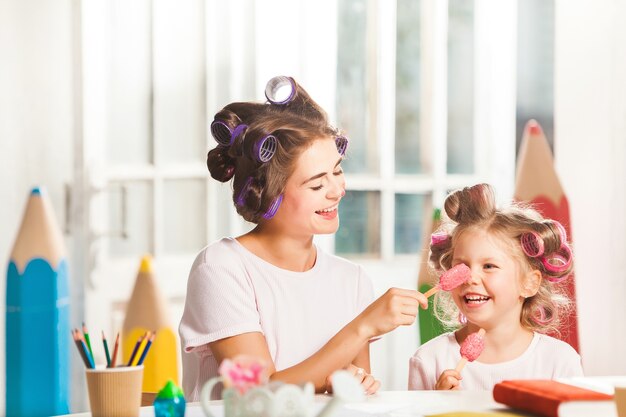 彼女の母親と一緒に座ってアイスクリームを食べる少女