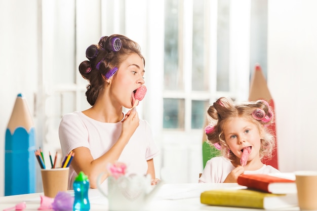 彼女の母親と一緒に座ってアイスクリームを食べる少女