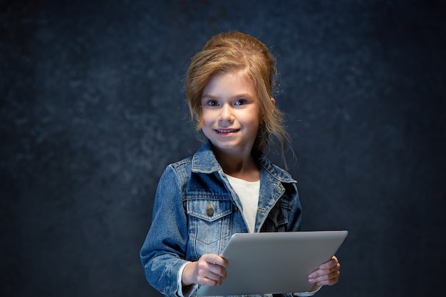 Бесплатное фото Маленькая девочка сидит с планшетом