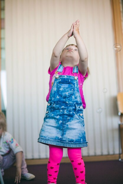 Little girl in skirt catching bubbles