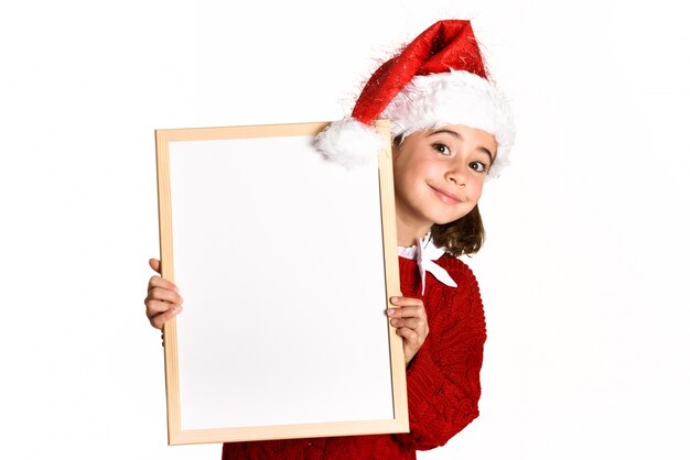 화이트 보드를 들고 산타 모자와 함께 웃 고있는 어린 소녀
