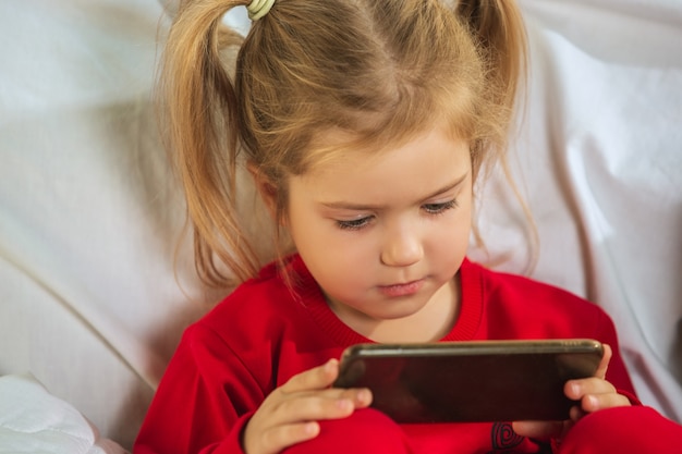 Free photo little girl in soft warm pajama playing at home