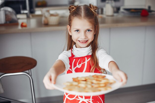 Little girl standing in a kitchen with cookies