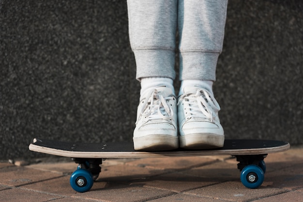 Free photo little girl standing on skateboard