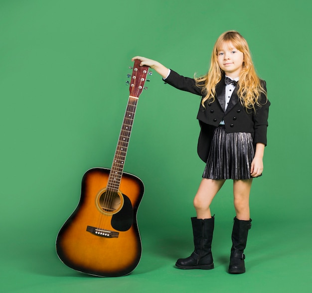 Little girl standing with acoustic guitar