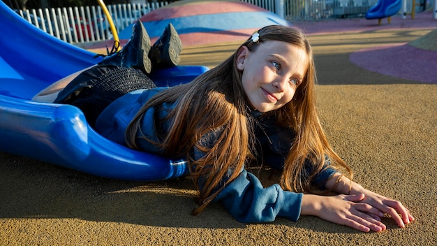 Little girl staying on the edge of a slide