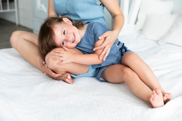 Little girl staying with her head on her mother's lap 