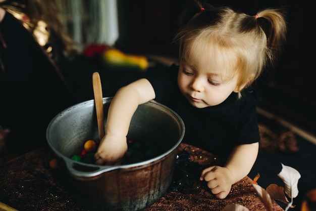 Little girl sticking her arm in a bowl with candies