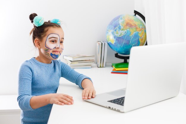 Little girl studying theater on laptop online