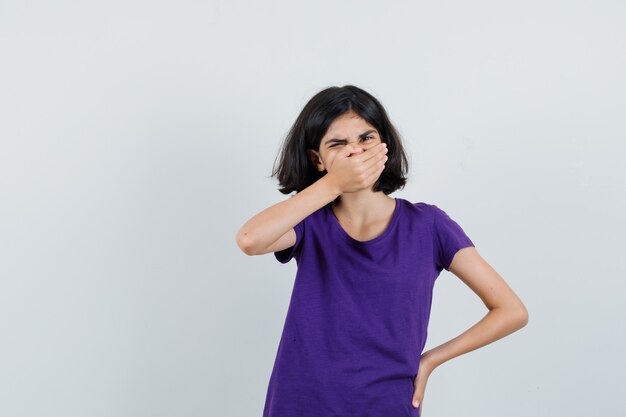 口に手をつないで苦しんでいるTシャツの少女、