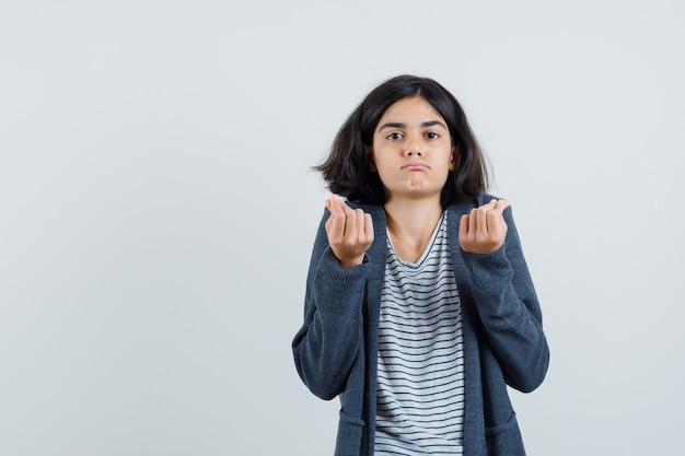 Tシャツを着た少女、お金のジェスチャーをし、貧しい人を探しているジャケット、