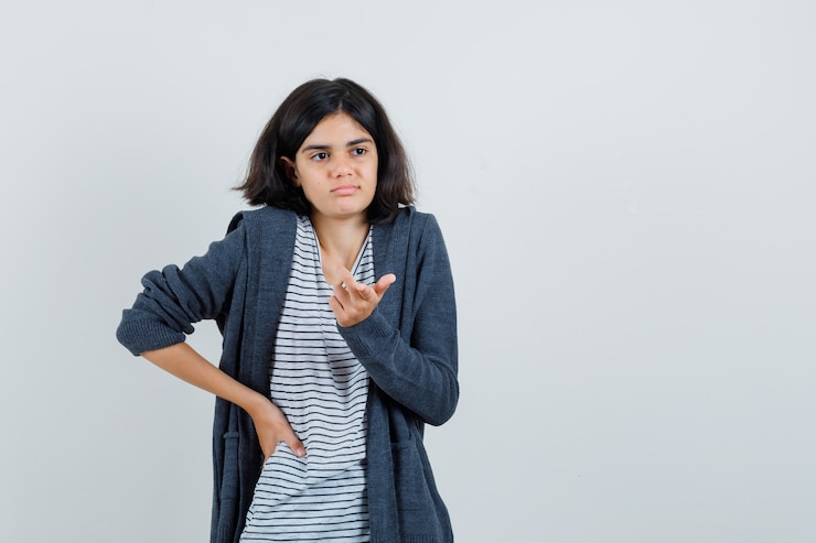 मुफ़्त फोटो little girl in t-shirt, jacket showing helpless gesture and looking confused ,