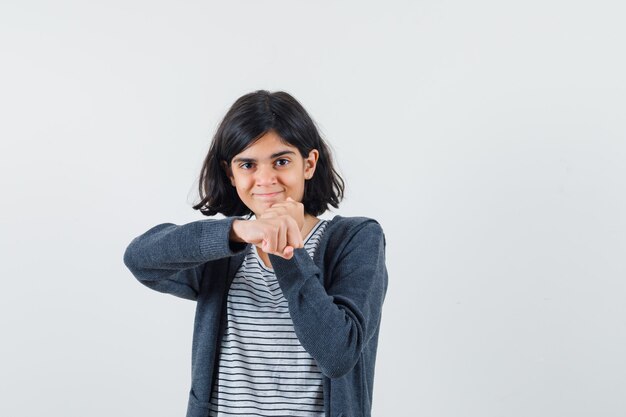 Little girl in t-shirt, jacket standing in a boxer pose and looking confident