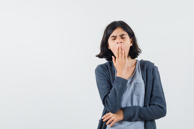 Free photo little girl in t-shirt, jacket yawning and looking sleepy