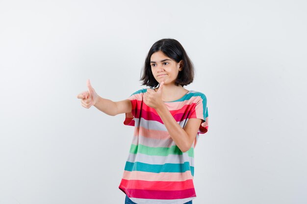 Little girl in t-shirt showing double thumbs up and looking pensive , front view.