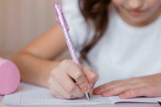 Little girl taking notes for an online class