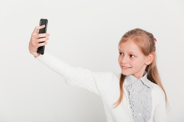 Little girl taking selfie with smartphone