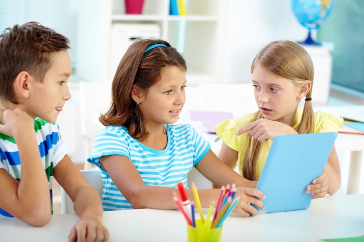 Free Photo little girl talking to her classmate