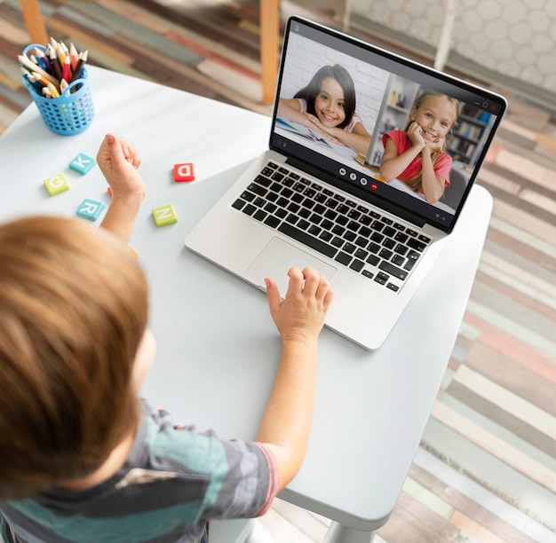 Little girl talking to her friends on a laptop in video call