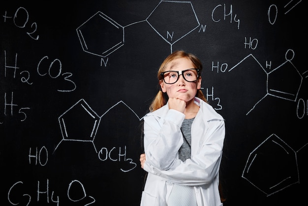 Free photo little girl thinking about new chemical bond