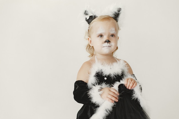Free photo little girl toddler dressed in black dress as a cat