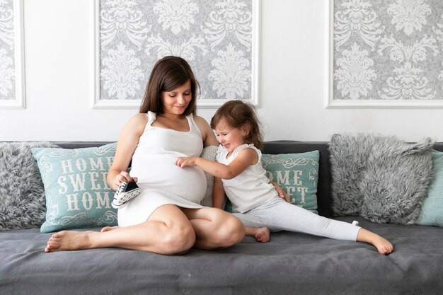 Little girl touching her mother belly