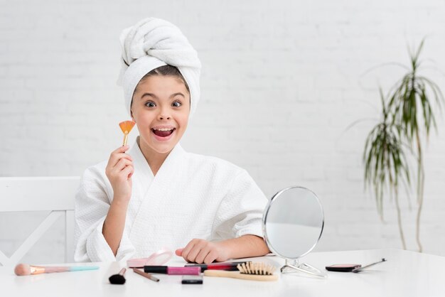 Little girl using her mothers illuminator brush