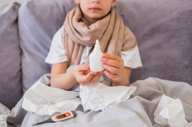 Little girl using nose spray