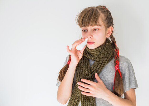 Little girl using nose spray